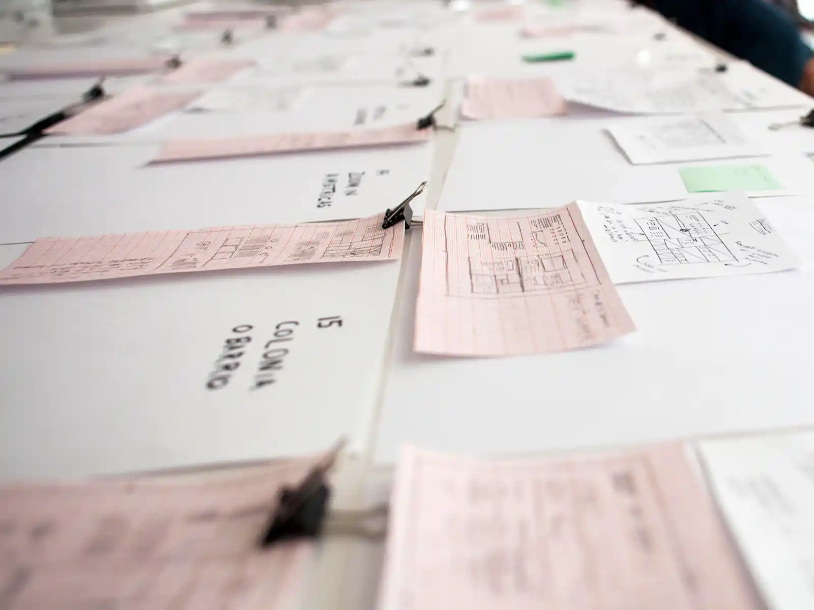 Hand-drawn website wireframe sketches laid out across a studio table